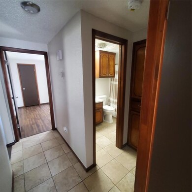 Corridor with a textured ceiling and light tile pa