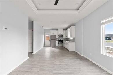 Kitchen featuring appliances with stainless steel finishes, a sink, healthy amount of natural light, light countertops, and crown molding