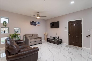 Tiled living room with ceiling fan and a wealth of natural light