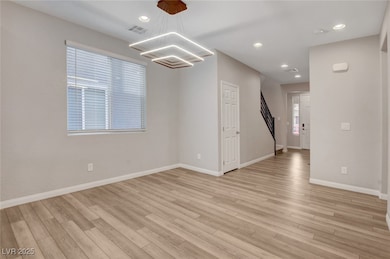Empty room featuring light wood-style floors, a ch