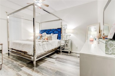 Downstairs bedroom featuring hardwood / wood-style floors and ceiling fan