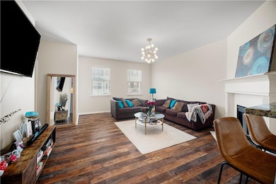 Living room with hardwood / wood-style floors, a chandelier, and a fireplace