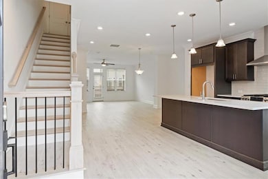 Kitchen featuring wall chimney exhaust hood, dark 