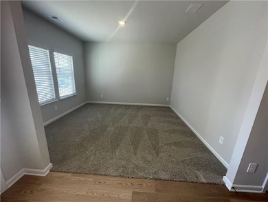 Unfurnished room with visible vents and baseboards