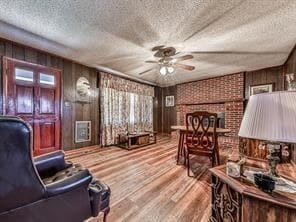 Sitting room featuring wood walls, a brick firepla