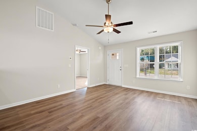 Unfurnished living room with lofted ceiling, wood finished floors, and a ceiling fan