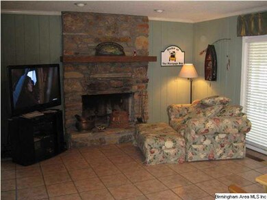 Family room with pretty rock fireplace and sliding