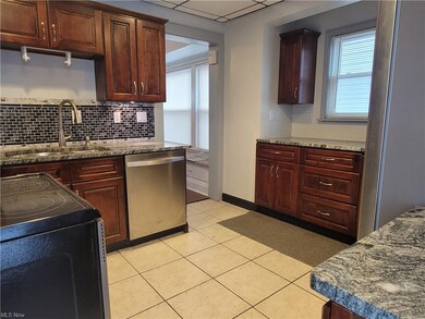 Wood cabinets, granite counters, and a glass backsplash are featured in the kitchen.