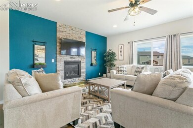 Living room featuring a stone fireplace, baseboards, recessed lighting, and a ceiling fan