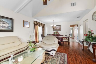 Living area with ceiling fan with notable chandeli