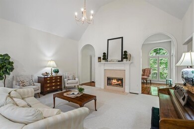 anchored with gas log fireplace centered on two arched entrees into sunroom