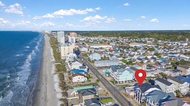 Birds eye view of property with a water view and a view of the beach