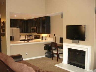 Living room with built-in desk area and kitchen br