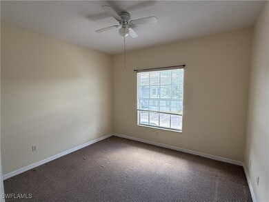 Carpeted spare room with a ceiling fan and baseboa