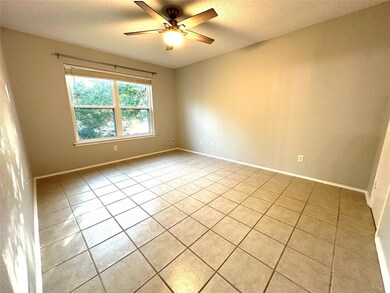 Spare room featuring light tile patterned floors, a textured ceiling, and ceiling fan