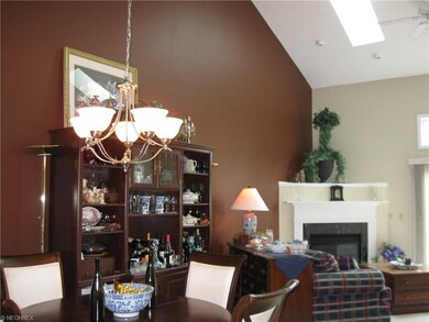 Great room offers volume ceiling, two skylights, transom window, accent wall and fireplace.