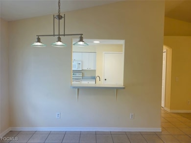 Unfurnished dining area with light tile patterned floors and arched walkways
