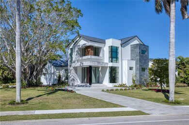 View of front of property featuring metal roof, a standing seam roof, a front yard, and stucco siding