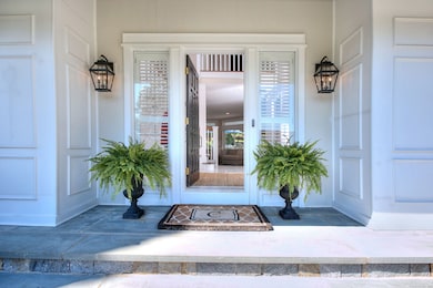 Grand blue stone front entrance, architectural exterior moldings, side light windows w/ plantation shutters.