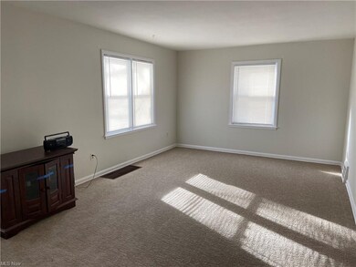 Sunny living room with neutral carpet and walls