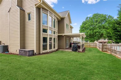 Back of house with fence, a yard, central air cond