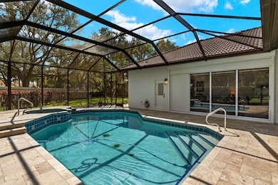 View of pool featuring a patio, a sunroom, a pool with connected hot tub, and a lanai