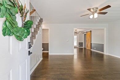 Entry to Living room that opens to dining.  Stairs on the left go to the second and third bedrooms and their full bathroom