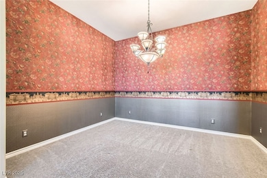 Unfurnished room with carpet floors, a chandelier,