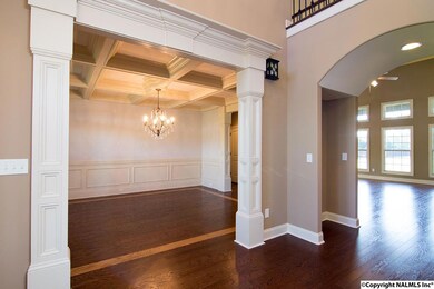 Wood mouldings, curved alcove, and classic lighting choices create a dramatic entry to the home.