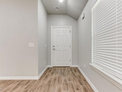 Entryway featuring wood tiled floors and vaulted ceiling