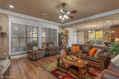 Living room with crown molding, hardwood / wood-st