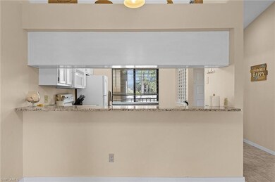 Kitchen with white appliances, light stone counter