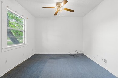 Empty room with dark colored carpet, baseboards, c