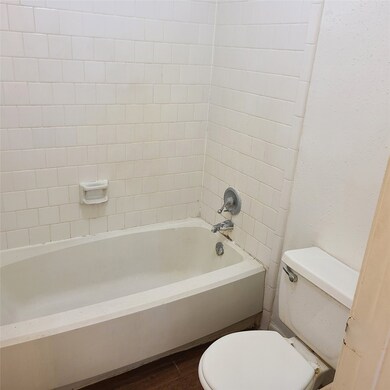The Tub Shower Combo Surrounded by Ceramic Tile.