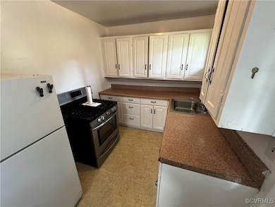 Kitchen featuring freestanding refrigerator, stain