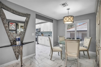 Dining space featuring baseboards and light marble finish flooring