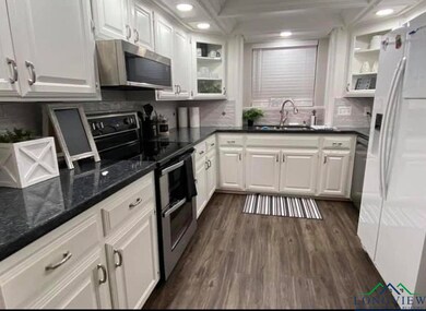 Kitchen featuring a sink, white cabinetry, tastefu