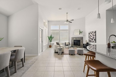 Living area with ceiling fan, light tile patterne