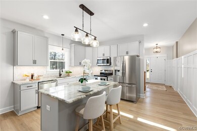 Kitchen featuring a center island, appliances with stainless steel finishes, pendant lighting, and light hardwood / wood-style floors