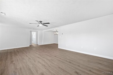 Unfurnished room featuring a chandelier, a ceiling fan, and wood finished floors