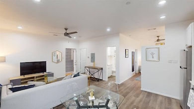 Living room featuring ceiling fan, light wood finished floors, and recessed lighting