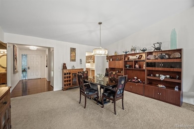 Dining space with carpet and a chandelier