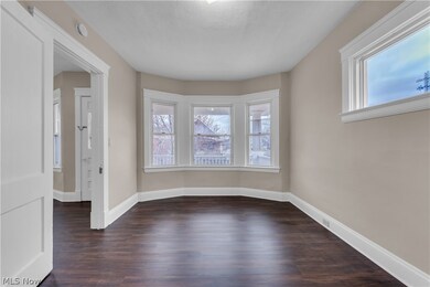 Spare room featuring dark hardwood / wood-style floors and a healthy amount of sunlight