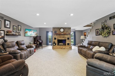 Living room featuring recessed lighting, carpet, and a fireplace