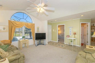 Living room with vaulted ceiling, a ceiling fan, a