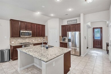 Kitchen featuring a kitchen island with sink, stai