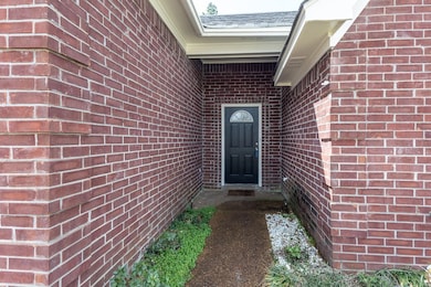 Entrance to property with brick siding and a shing