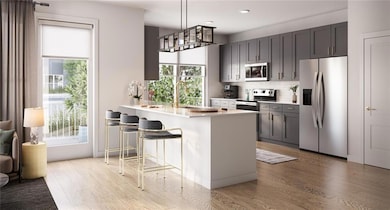Kitchen with pendant lighting, a kitchen bar, stainless steel appliances, sink, and kitchen peninsula