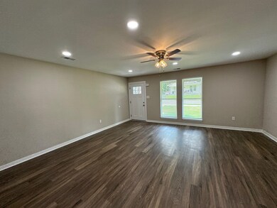 Spare room with a ceiling fan, dark wood-type flooring, and recessed lighting