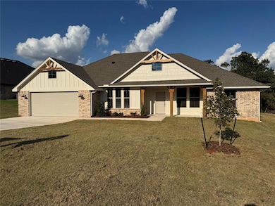 Craftsman-style home featuring board and batten siding, roof with shingles, covered porch, a front yard, and driveway